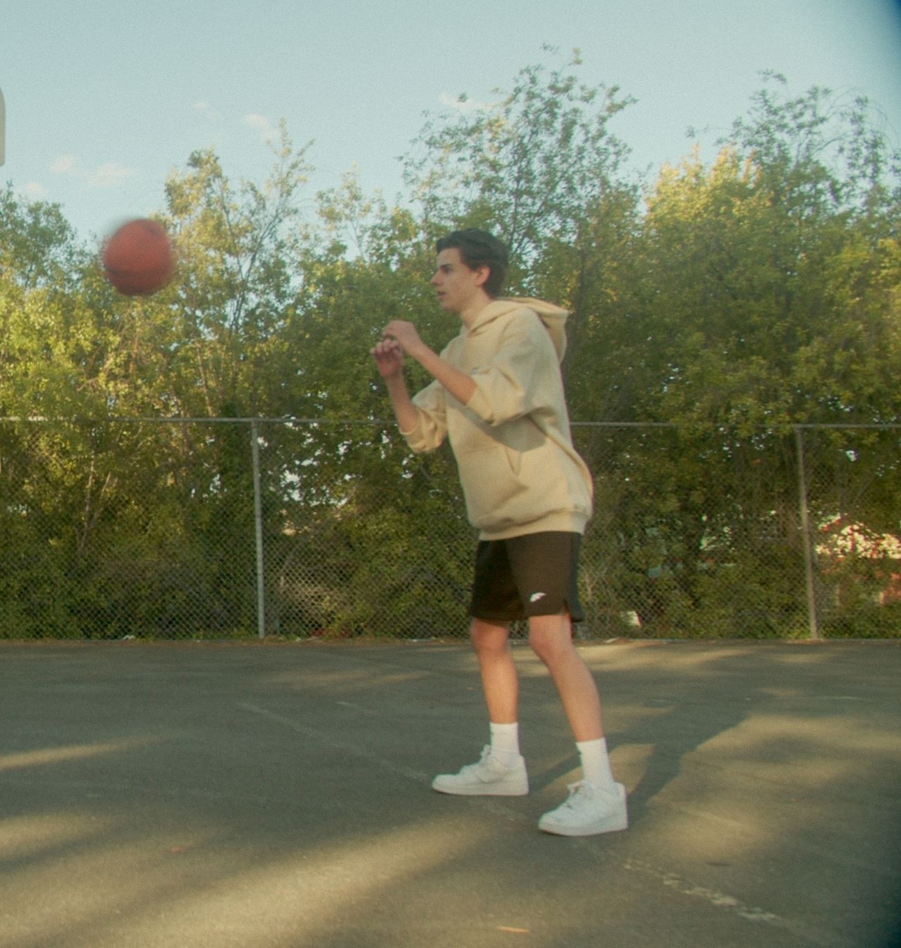 Passing the ball in the cream Angora hoodie and black shorts