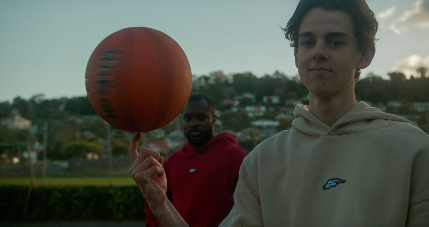 Spinning a basketball in the cream Angora hoodie